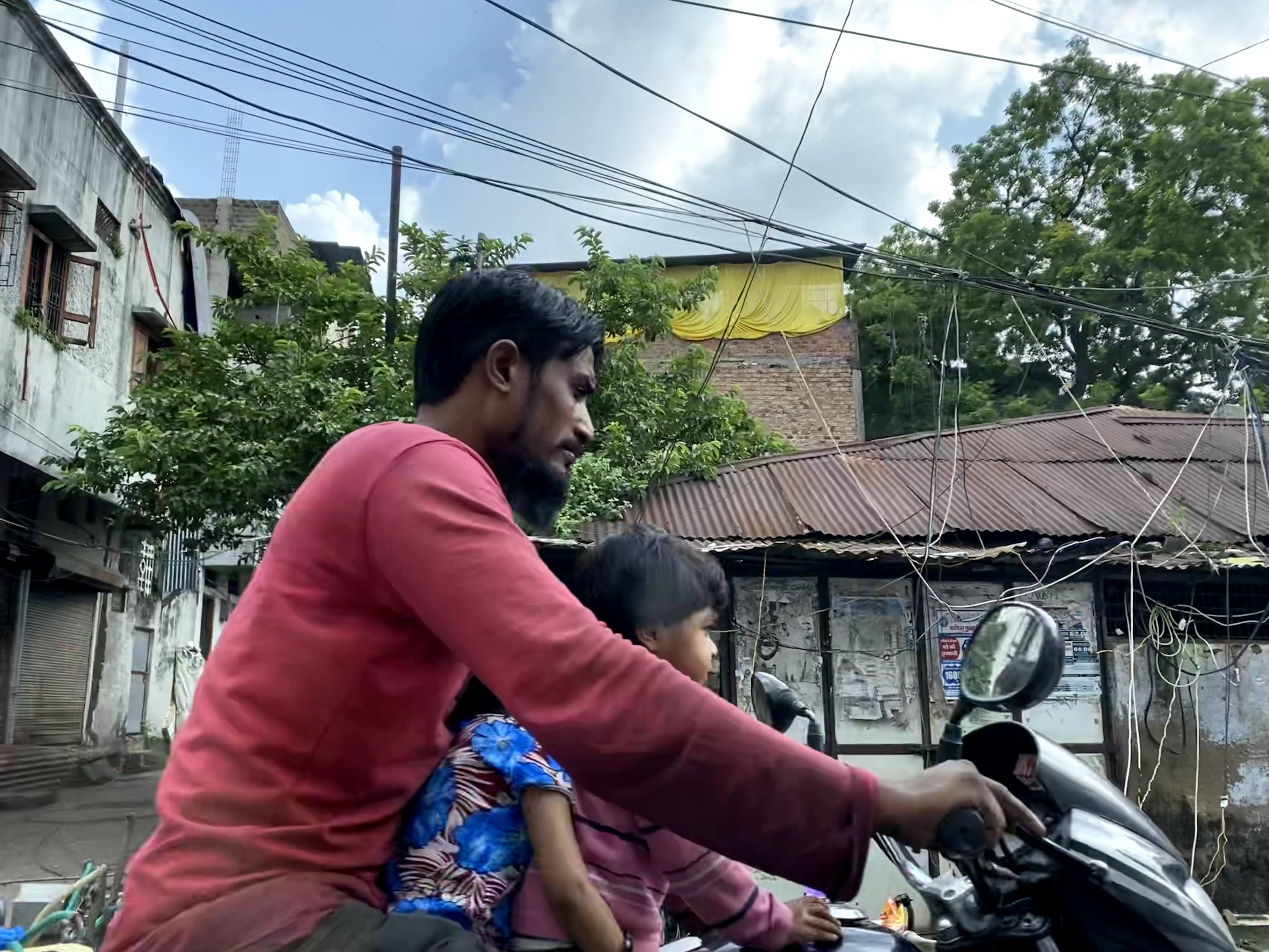 famille de 3 sur un scooter en inde