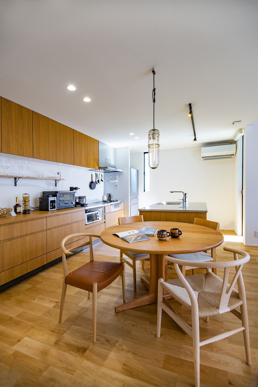 空間を広く見せる為、キッチンは換気扇を壁面に設置したⅡ型に。キッチンのワークトップはステンレス製で艶消し効果のあるバイブレーション仕上げ。