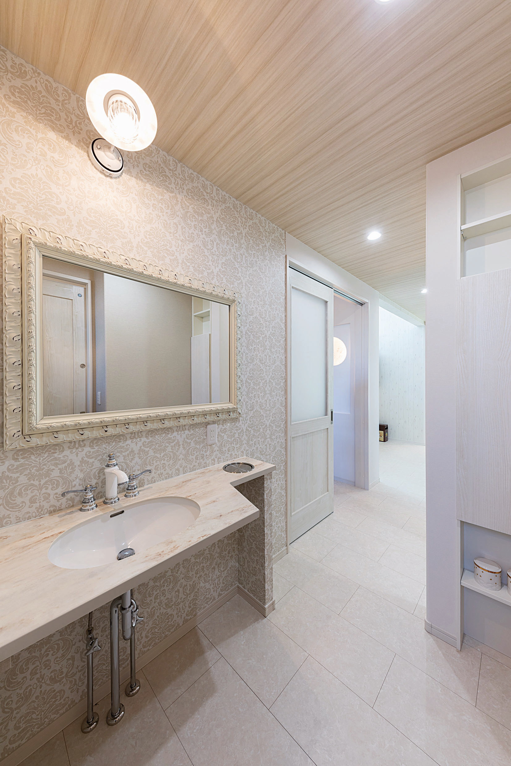 大好きなホテルの洗面室がイメージのもと、造作の洗面台とご主人が購入した鏡を組み合わせた手洗いスペース。