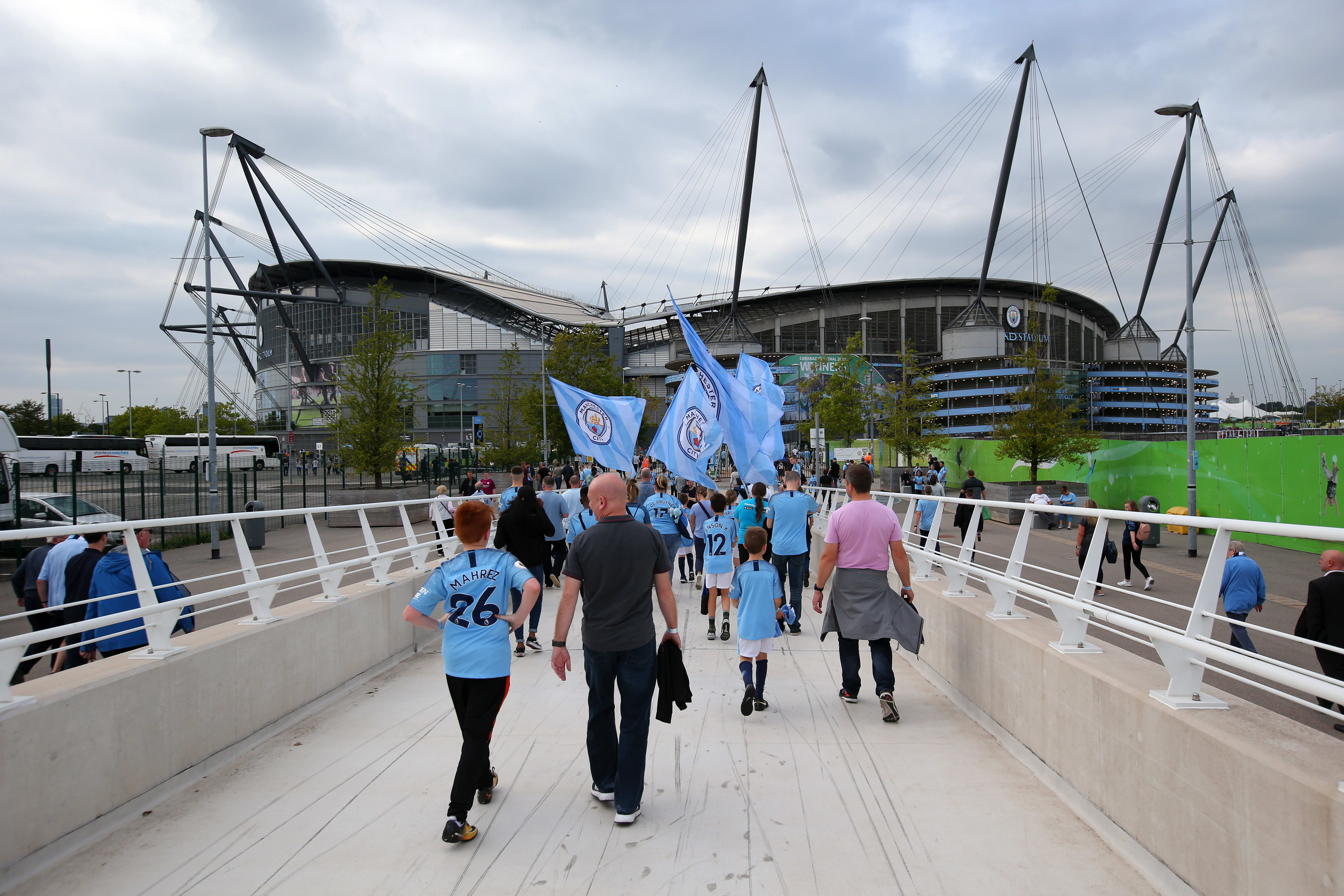 Manchester City fans marching towards the Etihad Stadium.