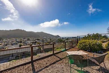 Spacious outdoor seating with table, chairs, and a beautiful ocean view