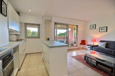 Grande pièce à vivre donnant sur terrasse avec salon, grand écran TV, cuisine...