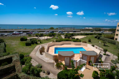 Vue sur la mer et la piscine de la copropriété