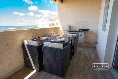 Terrasse avec salon de jardin, plancha, vue sur la piscine et la Méditerranée