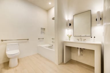 En-suite ADA bathroom with rain shower and high-end toiletries