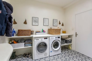 Buanderie équipée d'un lave linge et d'un sèche linge
