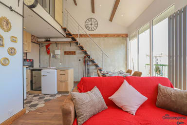 Espace séjour avec canapé convertible et espace repas à l'arrière