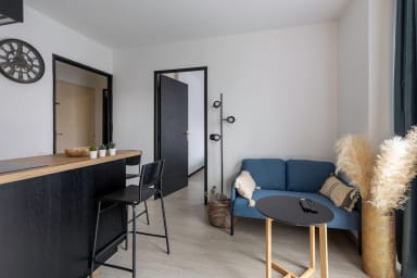une pièce à vivre avec canapé, télé et cuisine ouverte