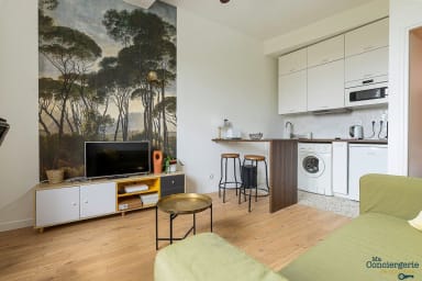 Petit salon avec canapé et cuisine ouverte; un coin repas, ventilateur de...