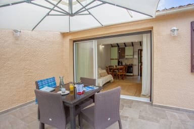 Grande terrasse ensoleillée avec mobilier de jardin