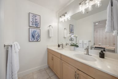 Comfortable bathroom featuring a bath, shower, toilet, and two sinks