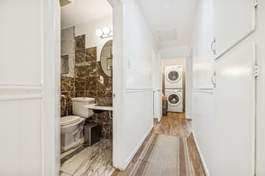 Secondary bathroom with standing shower and in home stackable washer and dryer. 