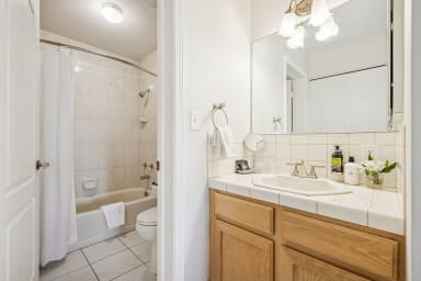 En-suite bathroom with shower/tub combination and high-end toiletries.