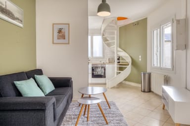 Salon avec canapé et cuisine en arrière plan