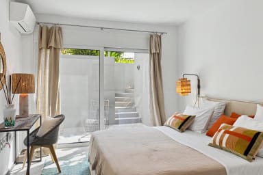 Sun-kissed bedroom with inviting bed and leafy views for morning inspiration.