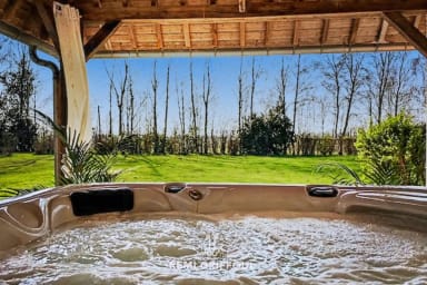 Moment de détente garantie dans le jacuzzi extérieur entouré de verdure.