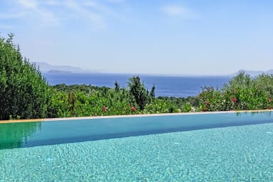 Piscine privée avec vue sur la mer Ionienne et les collines verdoyantes.