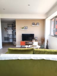 Pièce à vivre avec canapé convertible, TV écran plat, étagère de rangement