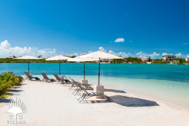 Shared community beach with loungers and umbrellas. 