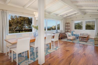 Windows with ocean view, tables, chairs, amazing decor