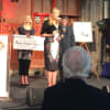 Caroline Barth, director of learning and participation at Derby Theatre, accepting the Clothworkers’ Theatre Award while executive director Rachael Thomas holds the cheque