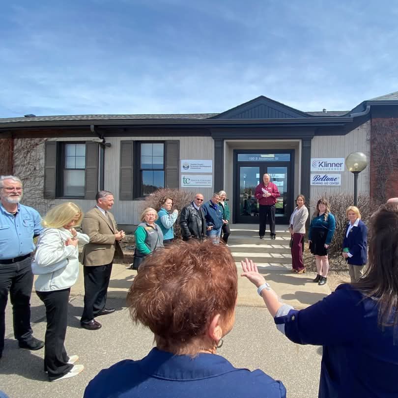 A group of people stands in a semicircle in front of a building during a ribbon-cutting ceremony, celebrating economic development and community partnerships in Oneida County, WI.