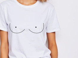 Eine Frau trägt ein weißes T-Shirt mit aufgemalten Brüsten.