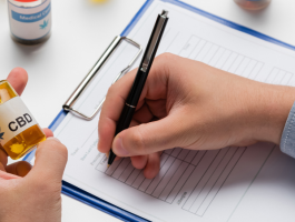 Arzt oder Ärztin hält eine CBD-Öl-Flasche in der Hand und füllt ein Rezeptformular aus – Symbolbild für die ärztliche Verschreibung von medizinischem Cannabidiol.