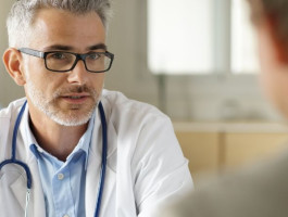 Ein Arzt im Gespräch mit einem Patienten.