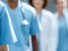 Medizinisches Fachpersonal in Klinikflur: Mehrere Ärztinnen und Ärzte sowie Pflegekräfte in Berufskleidung stehen nebeneinander. Symbolbild für Ärztemangel, Personalknappheit und Herausforderungen im Gesundheitssystem.