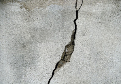 Ein großer Riss in einer grauen Betonwand.
