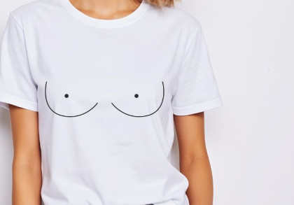 Eine Frau trägt ein weißes T-Shirt mit aufgemalten Brüsten.