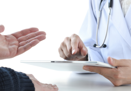 Ärztin mit Stethoskop nutzt Tablet zur digitalen Anamnese, während ein Patient seine Beschwerden schildert – Symbol für moderne Praxissoftware und effiziente digitale Arztpraxis.
