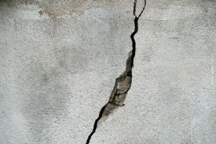 Ein großer Riss in einer grauen Betonwand.