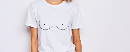 Eine Frau trägt ein weißes T-Shirt mit aufgemalten Brüsten.