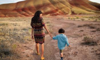 a little girl walking down a dirt road