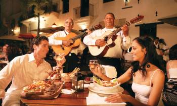 a group of people sitting at a table with food