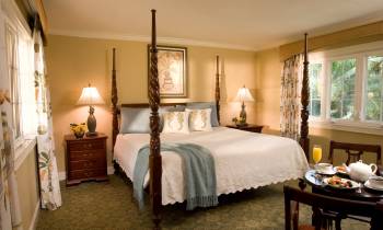 a bedroom with a bed and desk in a room