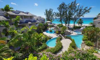 a resort near the water lined with palm trees
