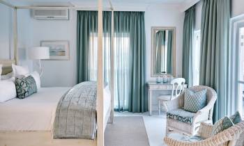 a bedroom with a bed and a chair in a room