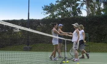 a group of people on a court with a racket