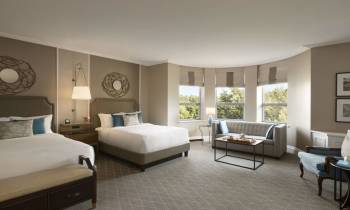 a bedroom with a bed and desk in a hotel room