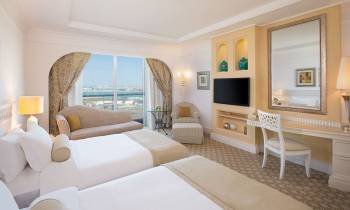 a bedroom with a bed and a chair in a room