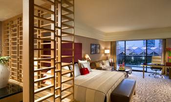 a bedroom with a bed and a chair in a room