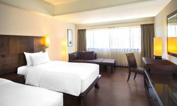 a bedroom with a bed and desk in a hotel room