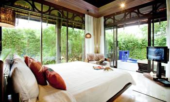 a bedroom with a bed and a large window