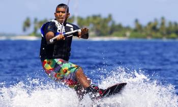 a man riding a snow board on a body of water