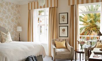a bedroom with a bed and a chair in a room
