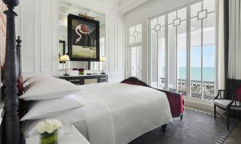 a large white bed sitting in a room