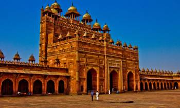 a large stone building with Fatehpur Sikri in the background